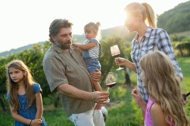 Winemaker family enjoying wine in vineyard